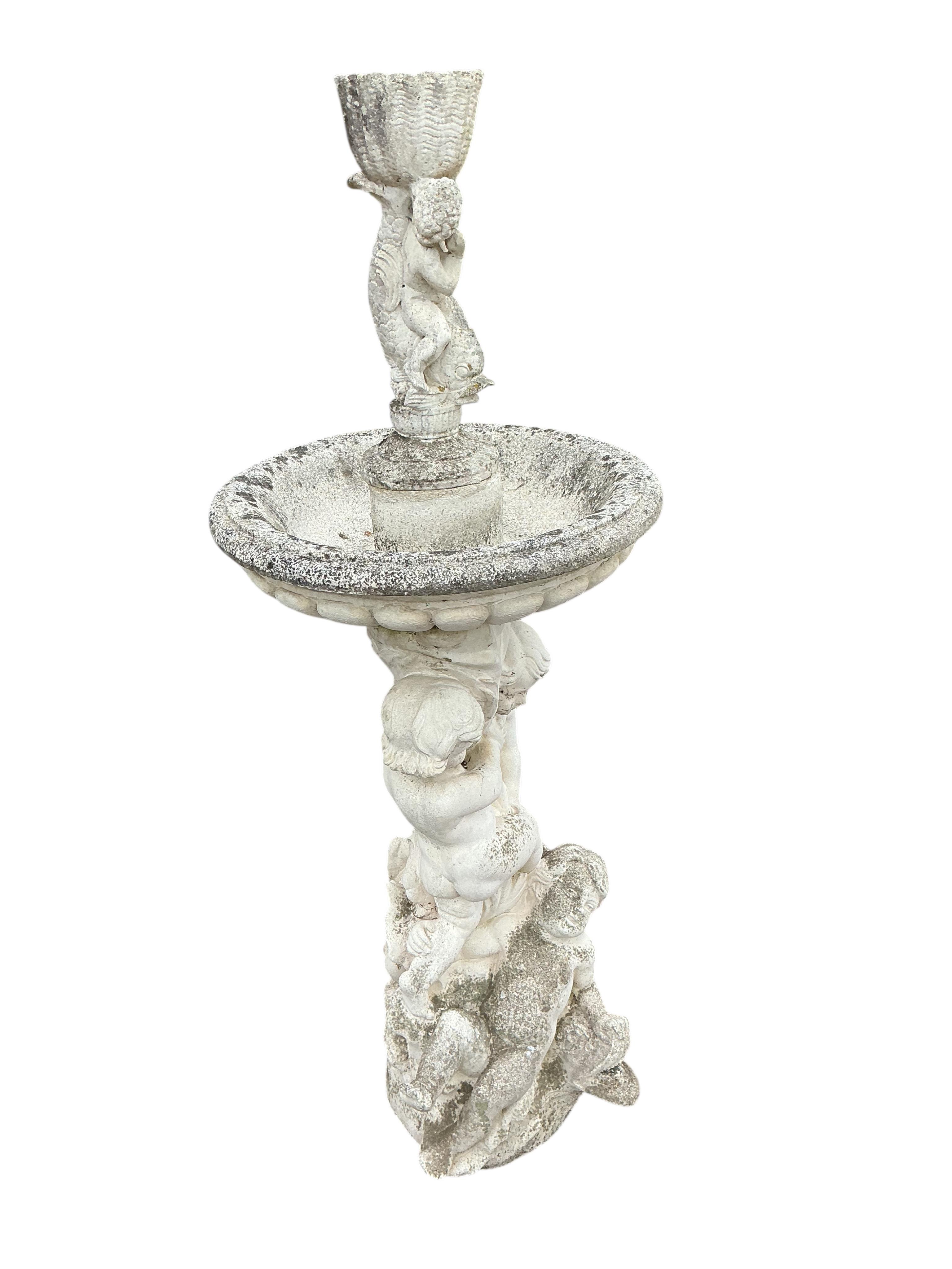A reconstituted stone cherub and dolphin garden fountain, height 134cm